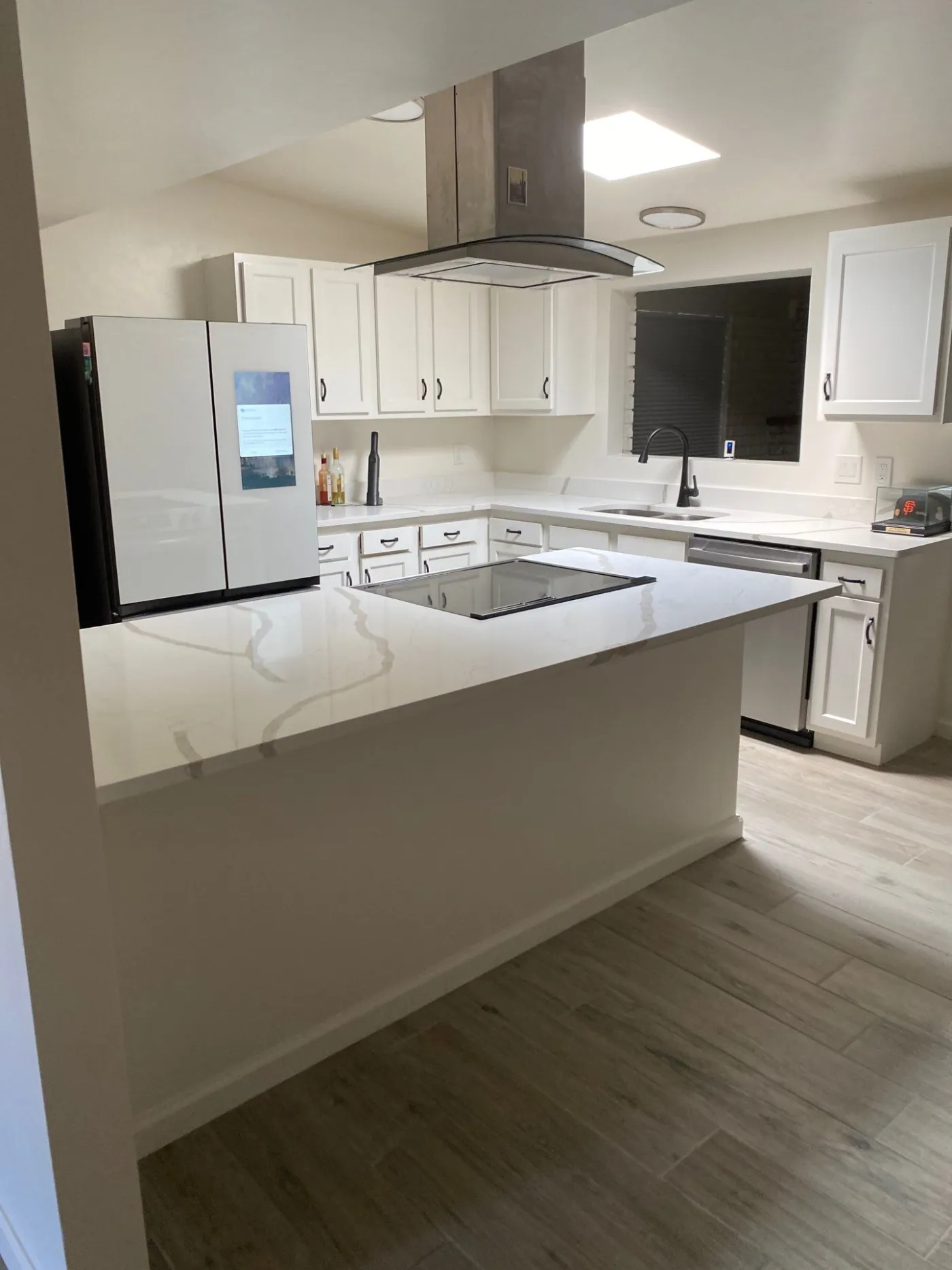 Finished custom kitchen with island and range hood by AHS Builders